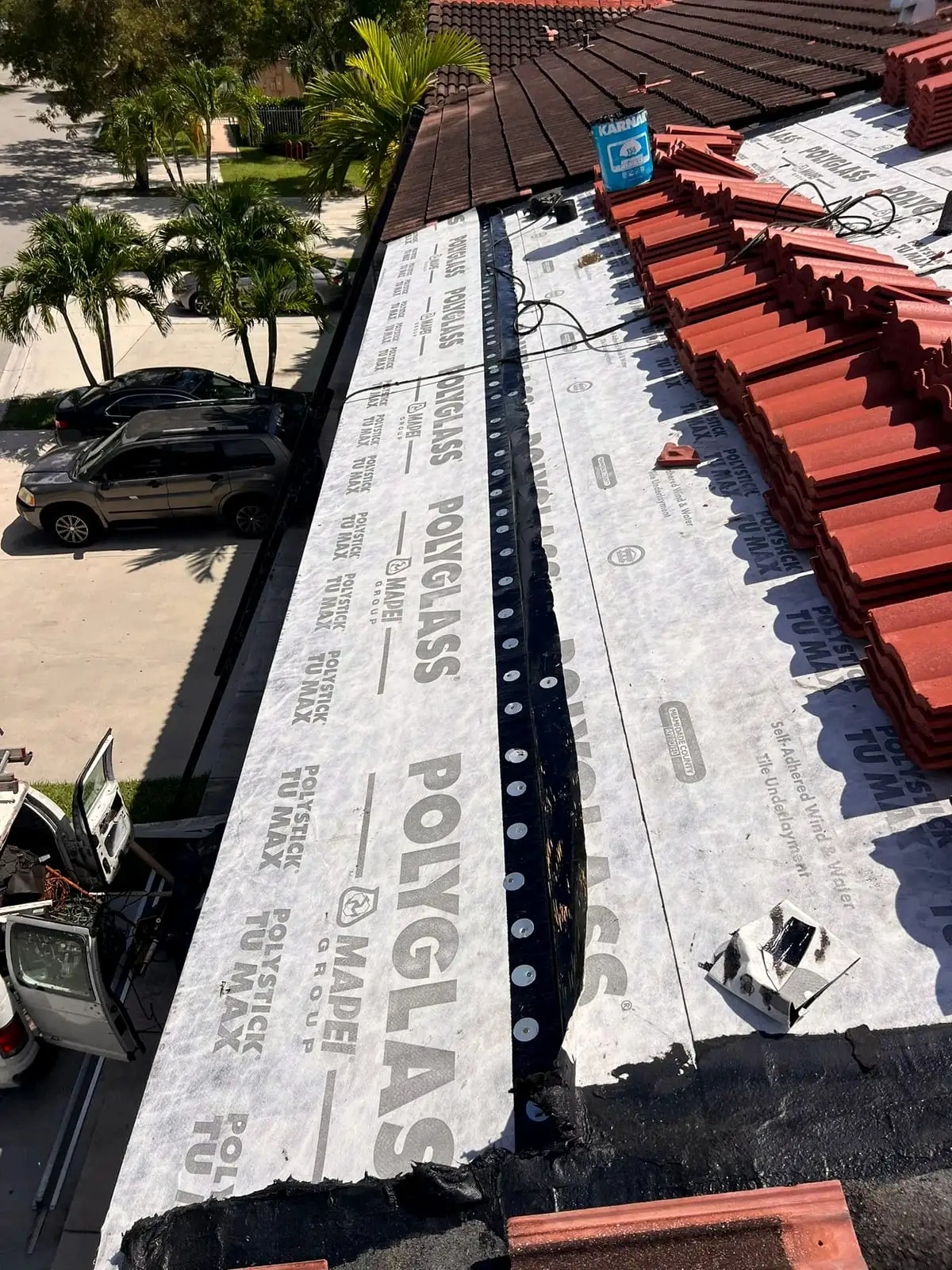 Polyglass underlayment on a roof with clay tile stacked along it, ready to install