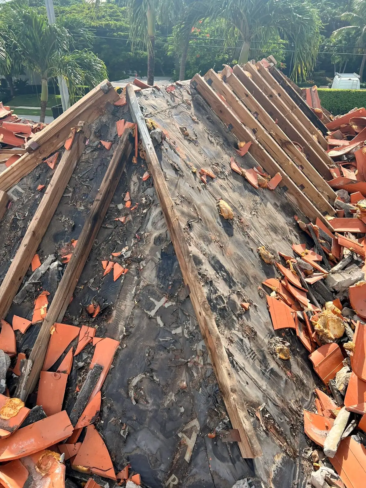 Tile stripped along a roof hip, exposing the old battens and underlayment under it