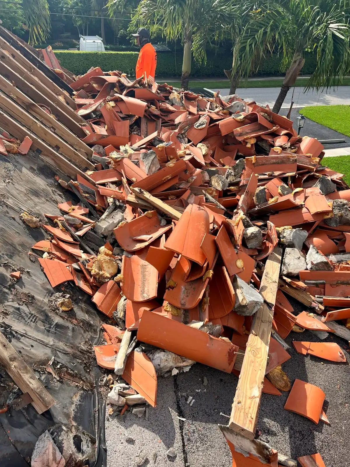 Old clay tile torn off a roof slope and piled over the battens during a replacement